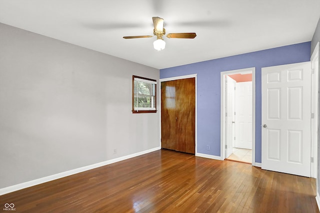 unfurnished bedroom with ceiling fan and dark wood-type flooring