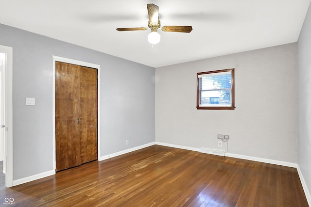 unfurnished bedroom with a closet, ceiling fan, and dark hardwood / wood-style flooring