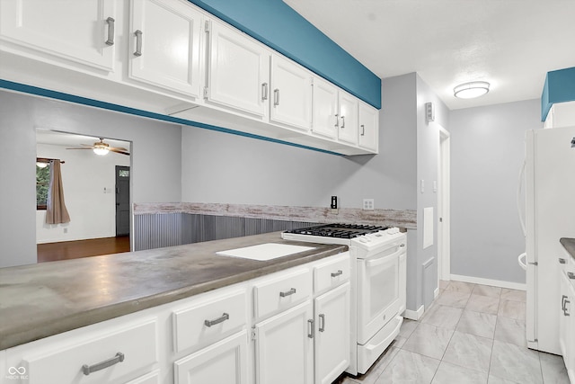 kitchen featuring ceiling fan, white appliances, and white cabinetry