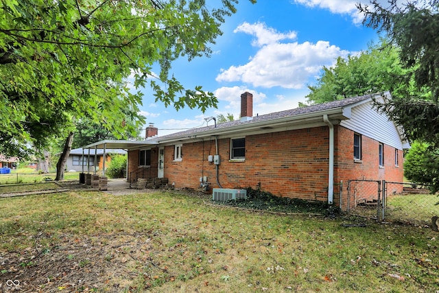 back of house with a lawn and cooling unit