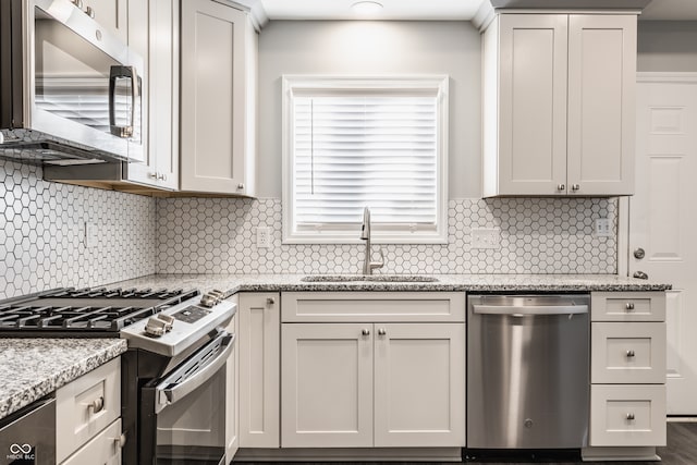 kitchen with stainless steel appliances, light stone counters, and backsplash