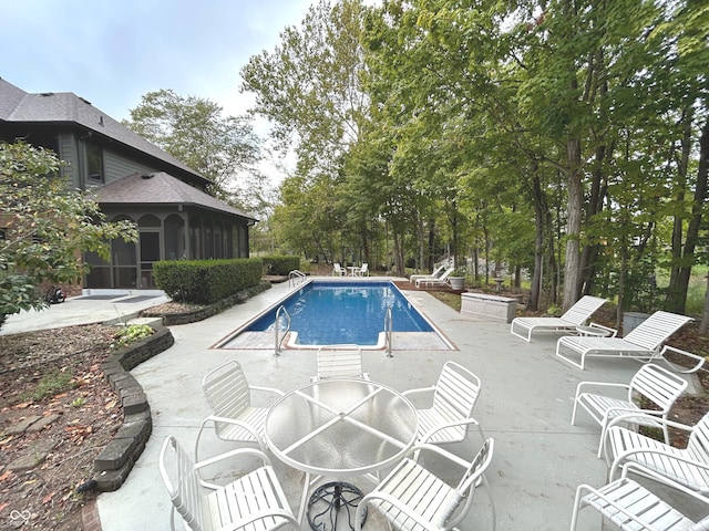 view of pool with a patio and a sunroom