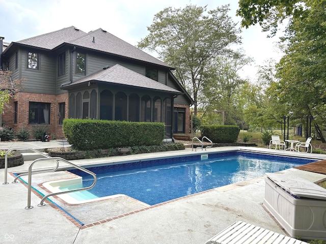 view of pool with a sunroom and a patio