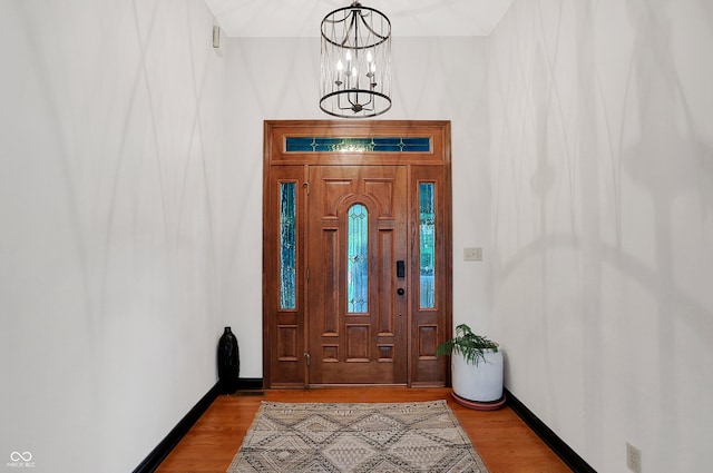 entryway with light wood-type flooring and a chandelier