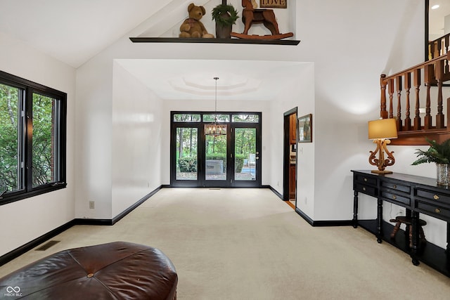 carpeted entrance foyer featuring a chandelier