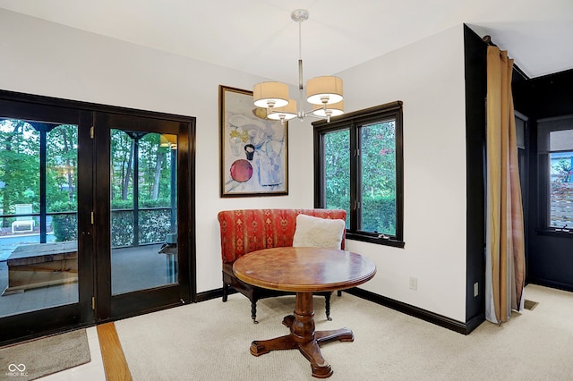 dining area with light carpet and a chandelier