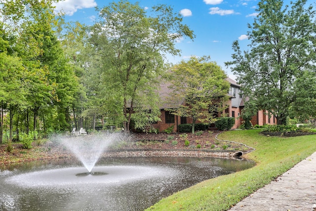 view of property's community with a yard and a water view