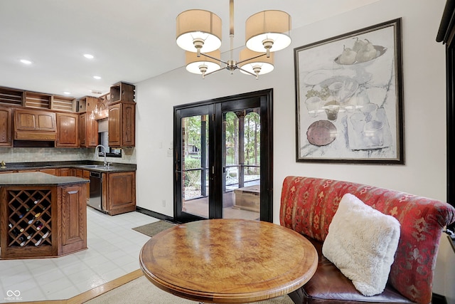 dining room featuring a notable chandelier, french doors, and sink