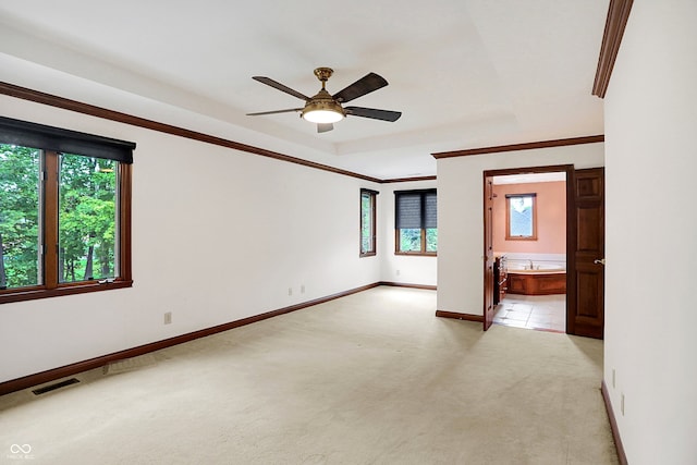 carpeted spare room featuring ceiling fan and crown molding