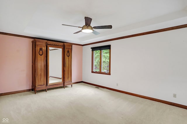 carpeted spare room with ceiling fan and crown molding