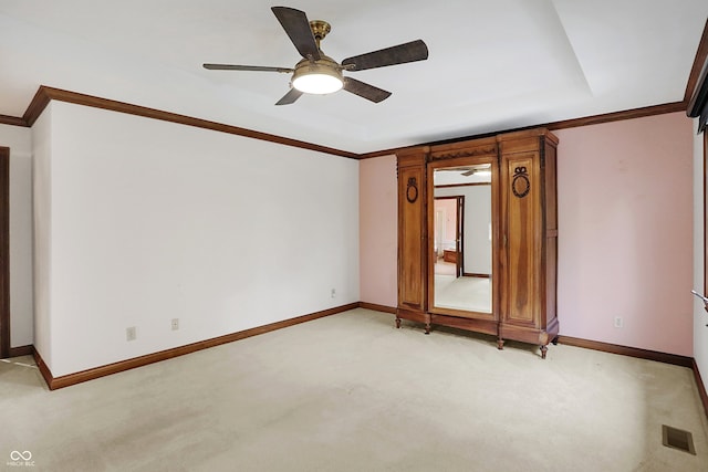 carpeted empty room with ceiling fan and crown molding