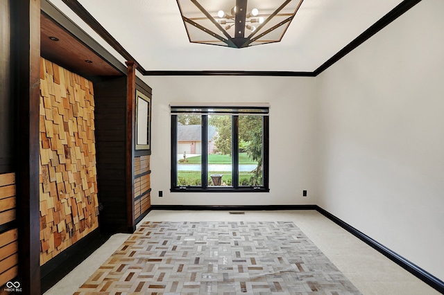 spare room featuring crown molding and a chandelier