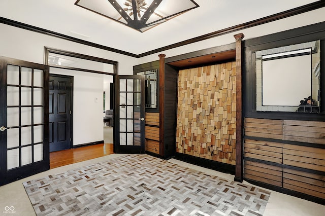 bedroom featuring crown molding, light hardwood / wood-style floors, and french doors