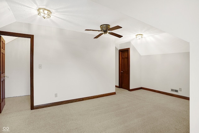 additional living space featuring vaulted ceiling, ceiling fan, and light colored carpet