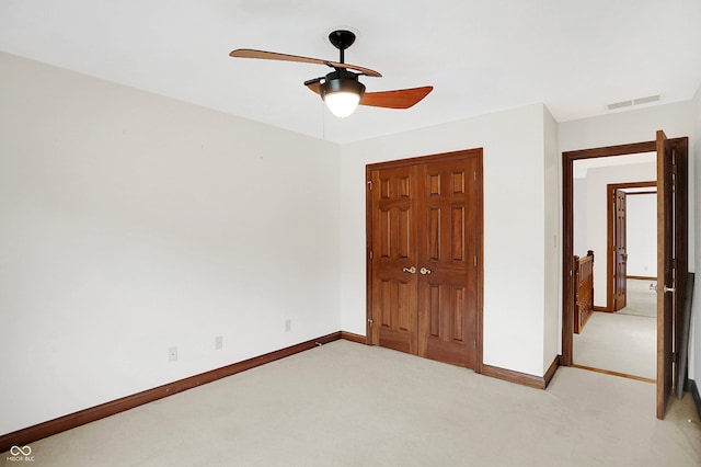 unfurnished bedroom with light carpet, a closet, and ceiling fan