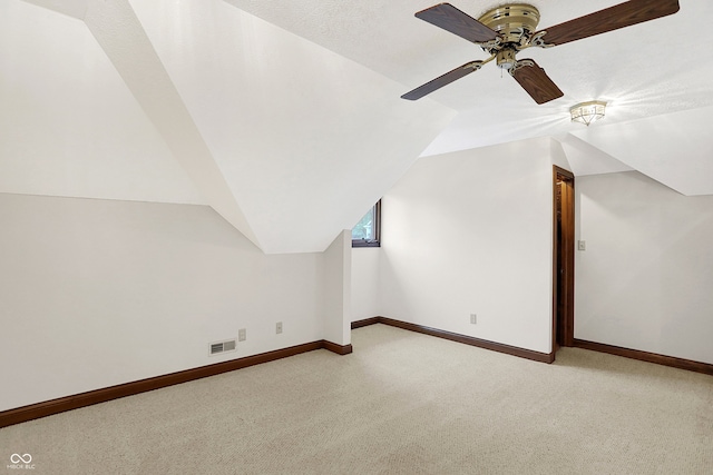 bonus room featuring vaulted ceiling, light carpet, and ceiling fan