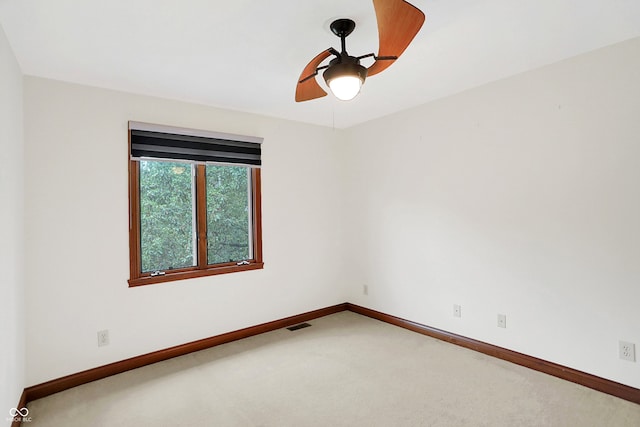 carpeted spare room featuring ceiling fan