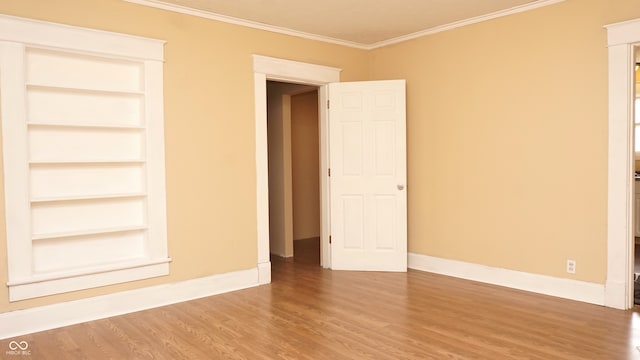 unfurnished bedroom with ornamental molding and hardwood / wood-style floors