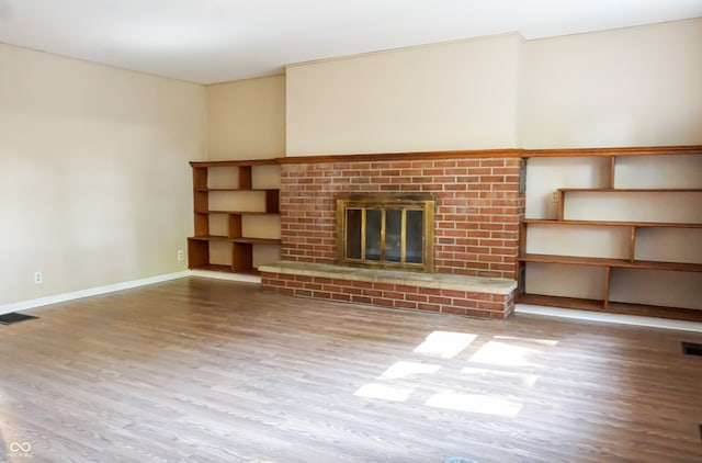 unfurnished living room featuring wood-type flooring and a fireplace