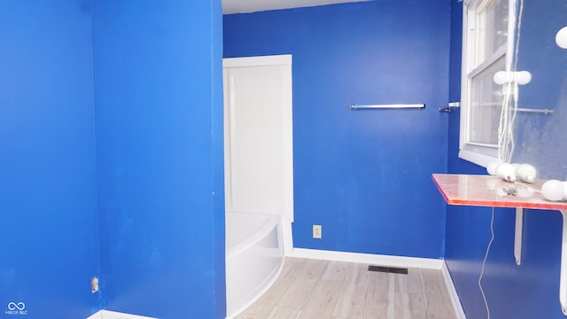 bathroom featuring hardwood / wood-style flooring and a bathing tub