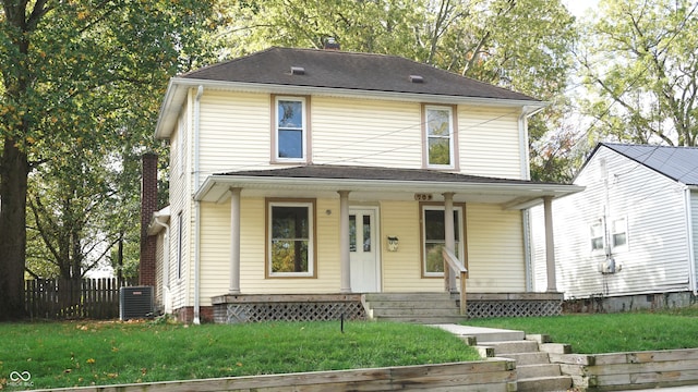 view of front of house with central AC, covered porch, and a front lawn