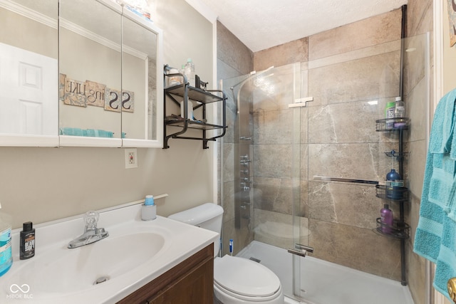 bathroom featuring toilet, a shower with shower door, ornamental molding, vanity, and a textured ceiling