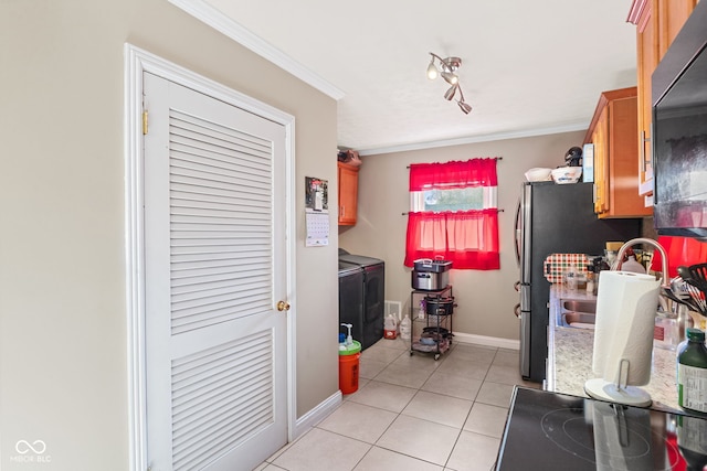 kitchen featuring stainless steel fridge, crown molding, washer and dryer, and light tile patterned floors