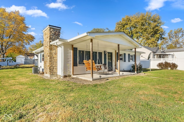 back of property featuring central air condition unit, a patio, and a lawn