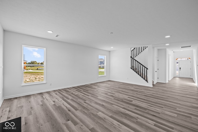 unfurnished living room featuring light hardwood / wood-style floors and a healthy amount of sunlight