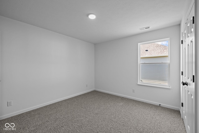 empty room featuring a textured ceiling and carpet floors