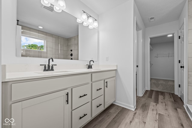 bathroom featuring vanity, hardwood / wood-style flooring, and tiled shower