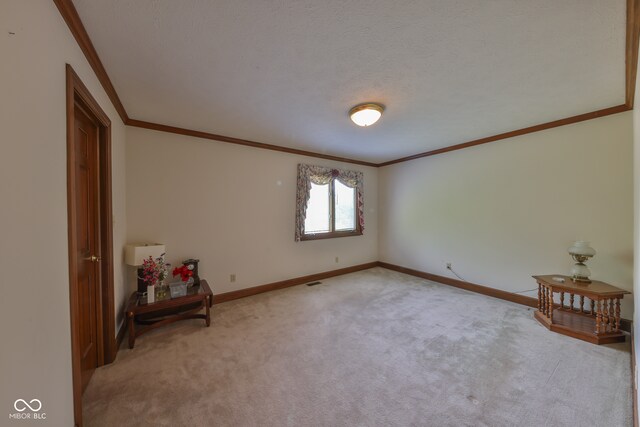 carpeted spare room featuring a textured ceiling and crown molding