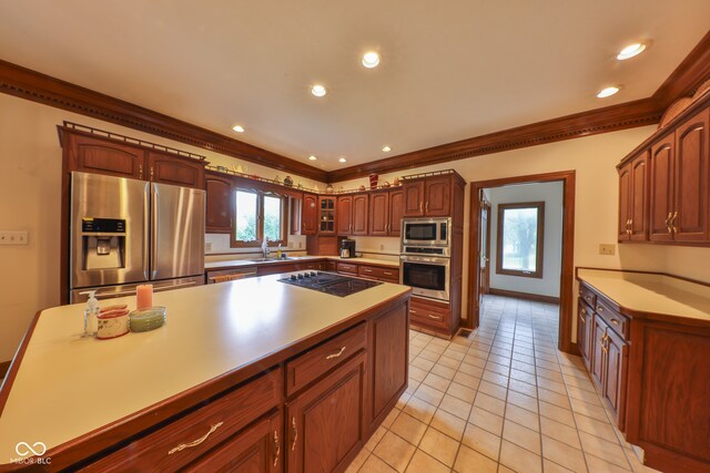 kitchen with ornamental molding, stainless steel appliances, light tile patterned flooring, and sink