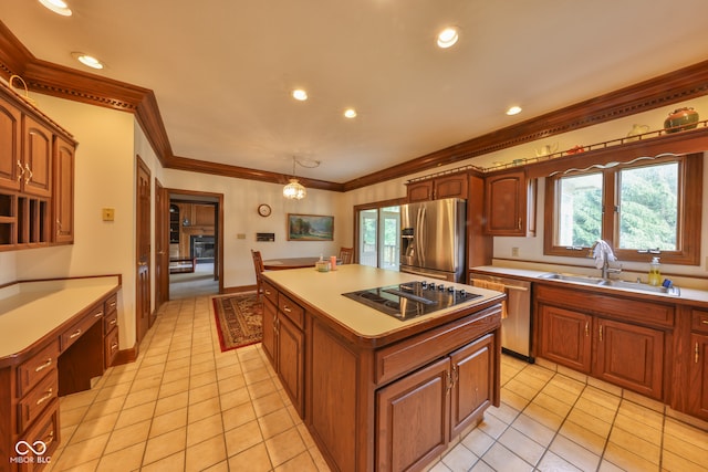 kitchen with a center island, sink, hanging light fixtures, stainless steel appliances, and ornamental molding