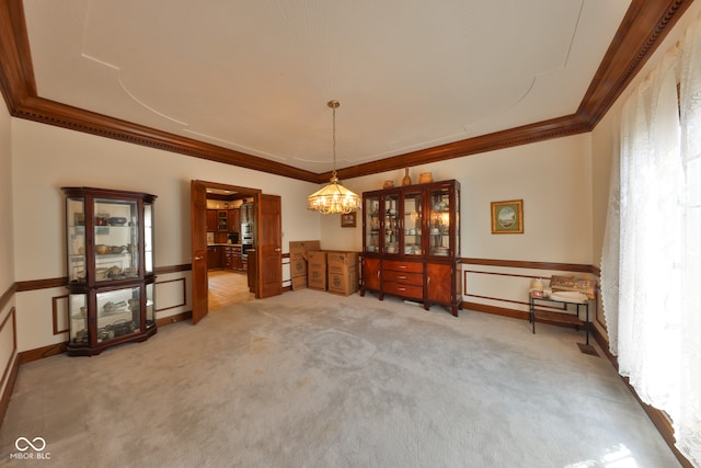 carpeted spare room with crown molding, a wealth of natural light, and a notable chandelier