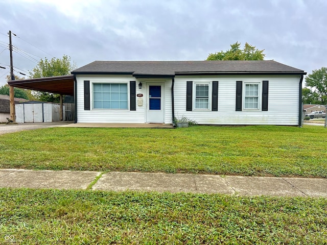 view of front of house with a front yard, a storage unit, and a carport