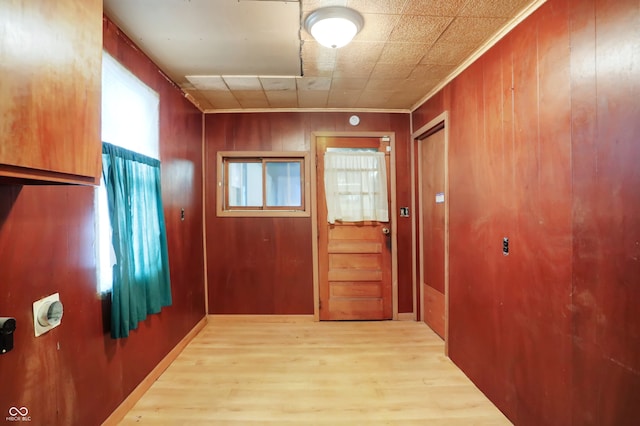 doorway to outside featuring wooden walls, hardwood / wood-style flooring, and crown molding