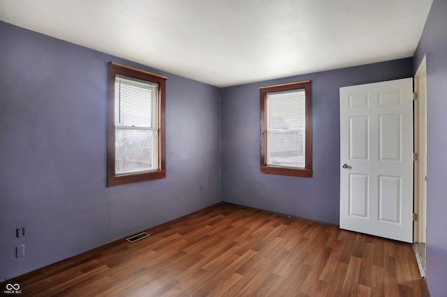 unfurnished room with dark wood-type flooring