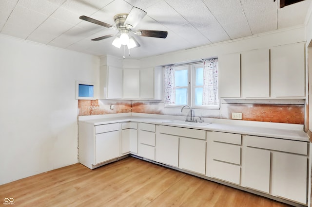 kitchen with light hardwood / wood-style floors, tasteful backsplash, sink, white cabinets, and ceiling fan