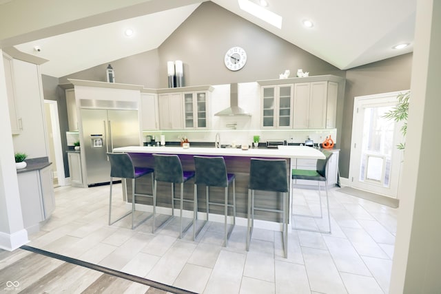 4270 Victoria Ln, Avon, IN 46123 - kitchen with stainless steel built in refrigerator, wall chimney range hood, a breakfast bar area, an island with sink, and glass insert cabinets