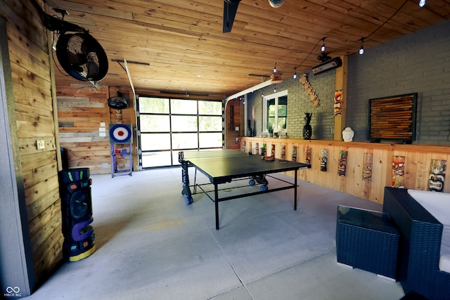 game room featuring wood ceiling, brick wall, wooden walls, and concrete floors