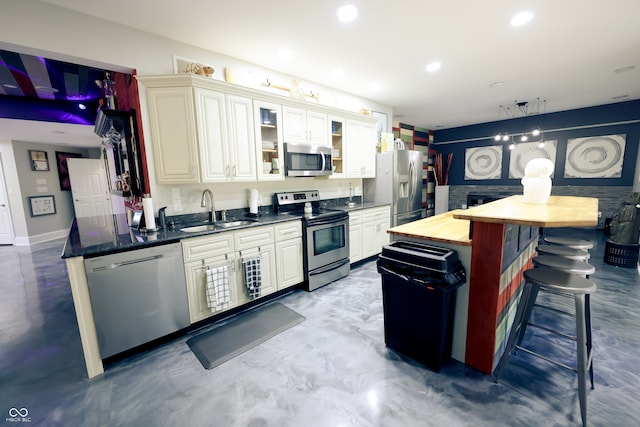 kitchen featuring white cabinetry, concrete flooring, butcher block counters, sink, and stainless steel appliances