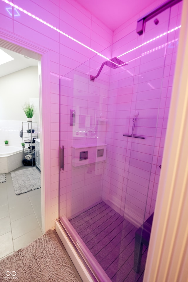 bathroom featuring tile patterned flooring and shower with separate bathtub