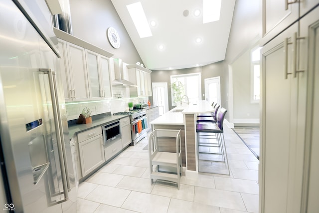 kitchen with tasteful backsplash, sink, high end appliances, and white cabinets