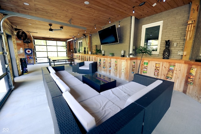 interior space featuring brick wall, wooden walls, ceiling fan, and wooden ceiling