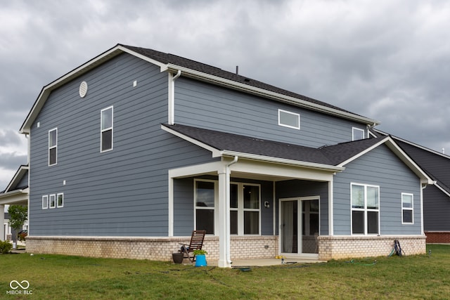 rear view of property featuring a lawn