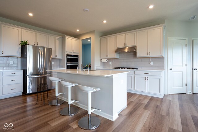 kitchen featuring appliances with stainless steel finishes, backsplash, and light hardwood / wood-style flooring