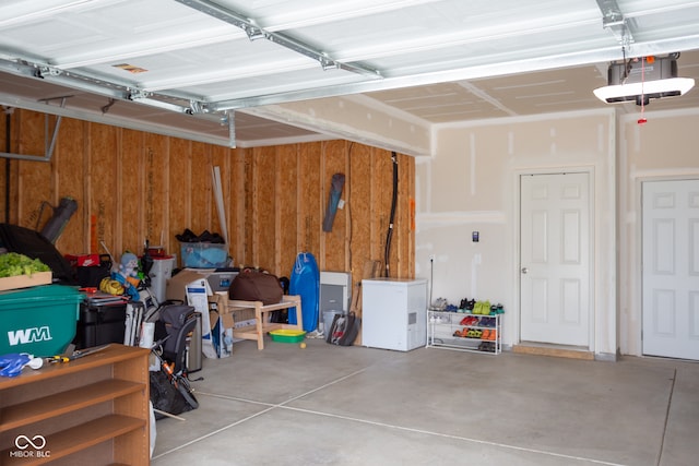 garage with a garage door opener and wooden walls