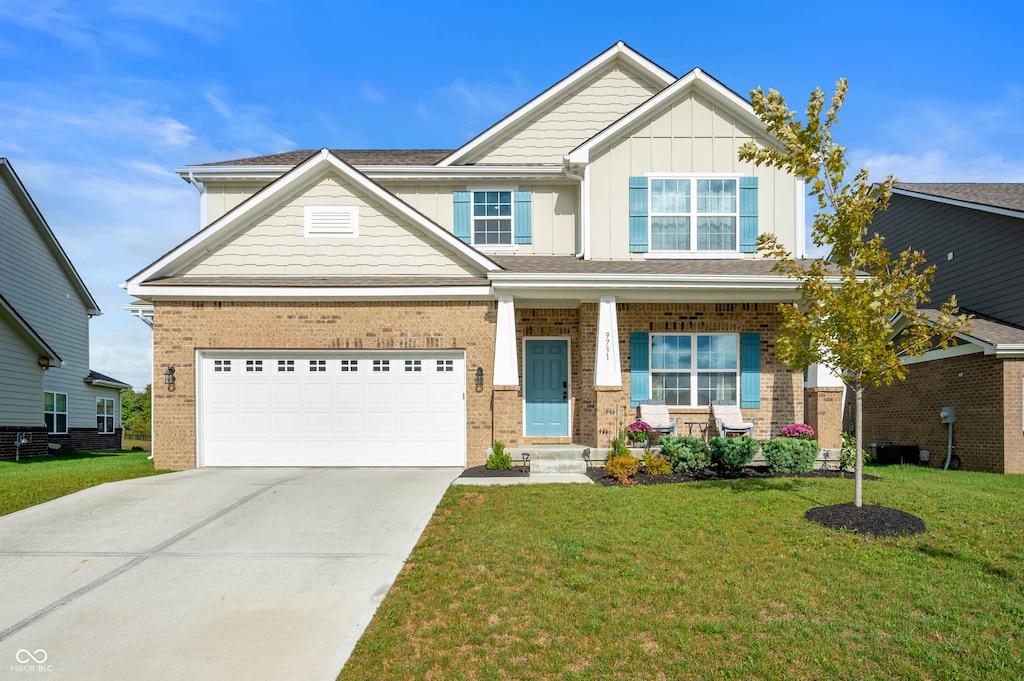 craftsman-style home featuring covered porch, a front yard, and a garage