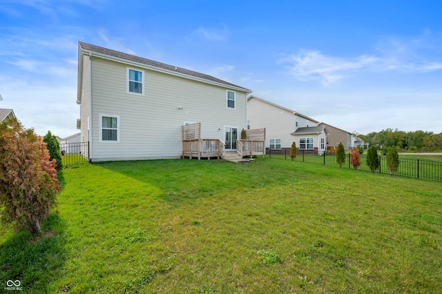 back of property with a deck and a lawn